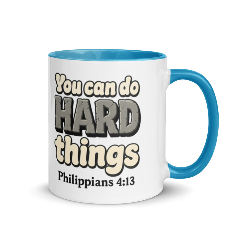 White mug with a blue inside and handle printed with “You can do HARD things” in cracked stone letters and Philippians 4:13