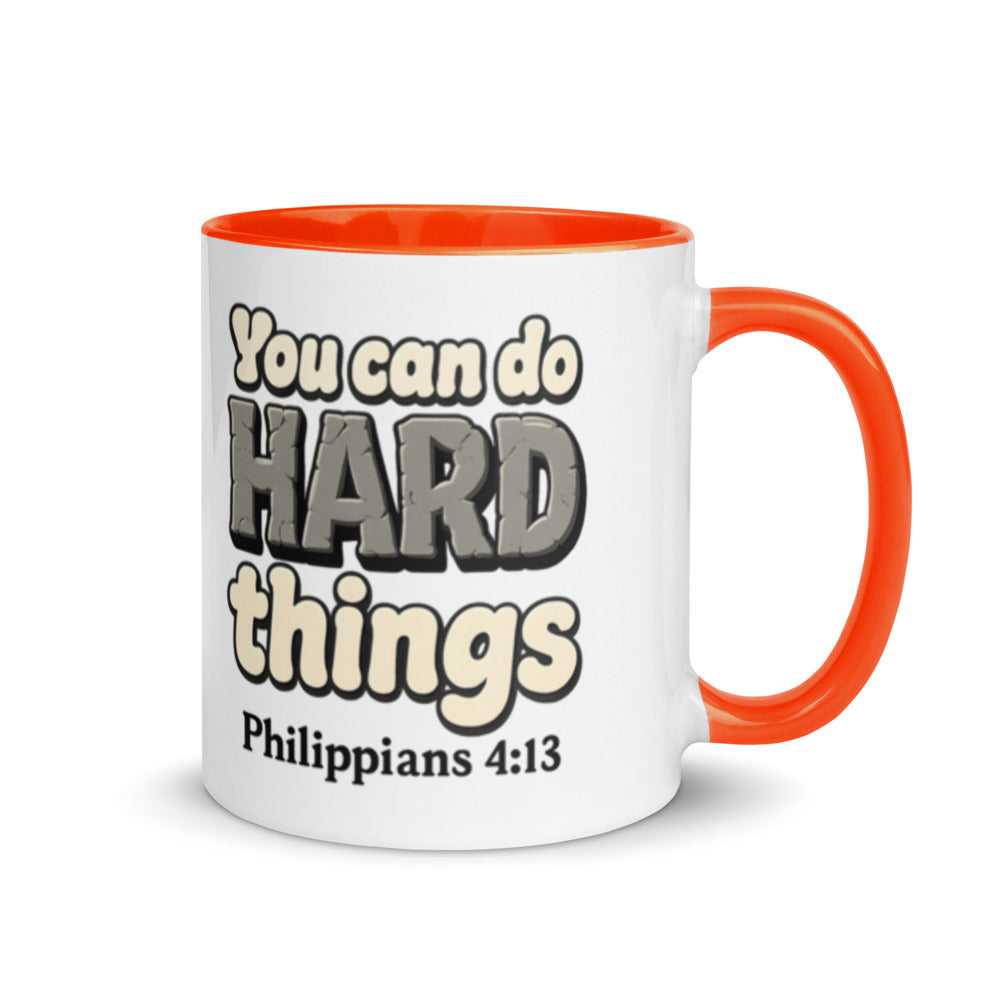 White mug with a orange inside and handle printed with “You can do HARD things” in cracked stone letters and Philippians 4:13