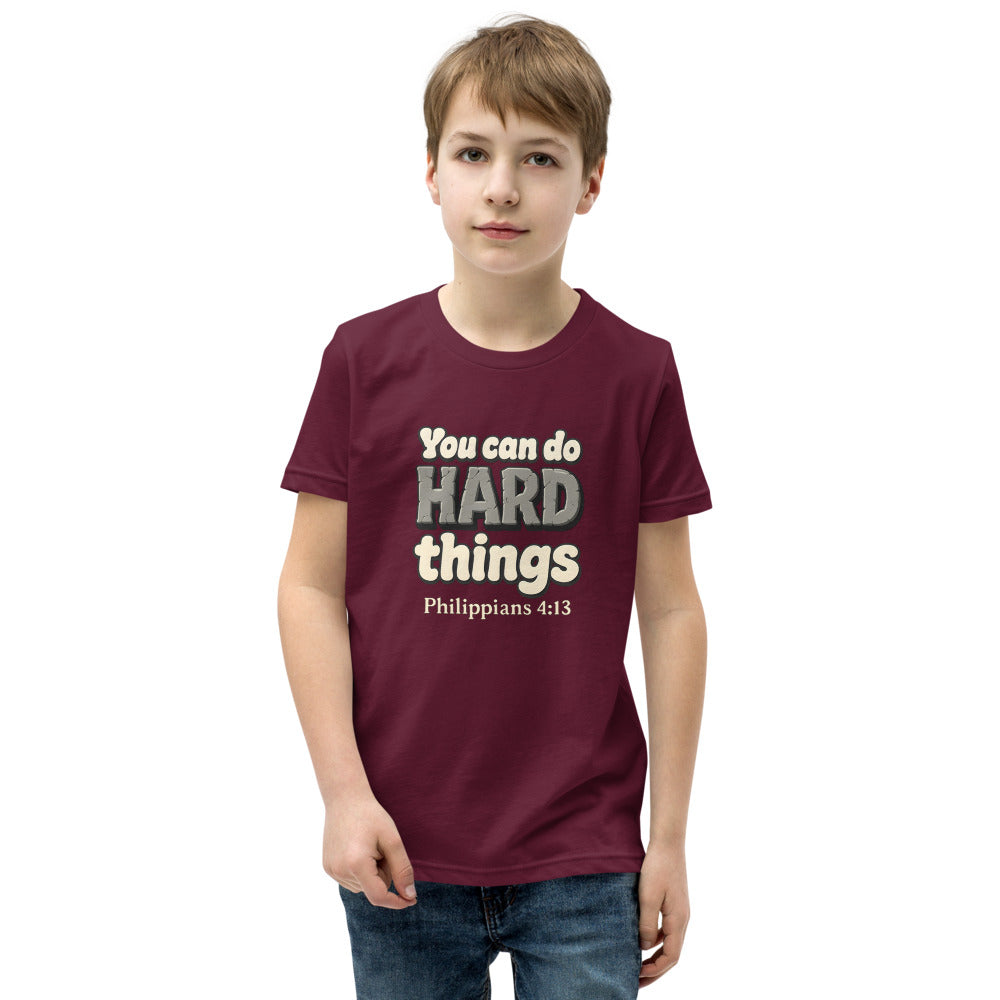 Maroon youth t-shirt printed with “You can do HARD things” in cracked stone letters and Philippians 4:13