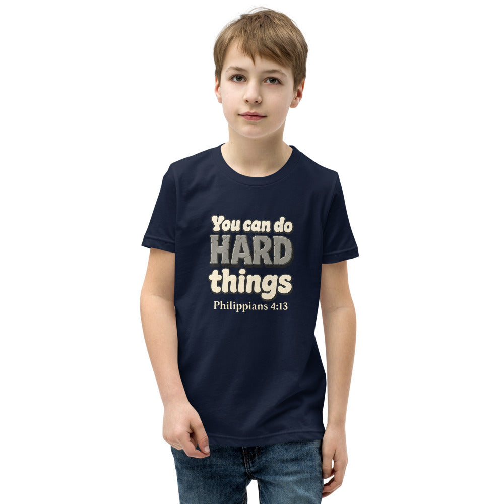 Navy youth t-shirt printed with “You can do HARD things” in cracked stone letters and Philippians 4:13