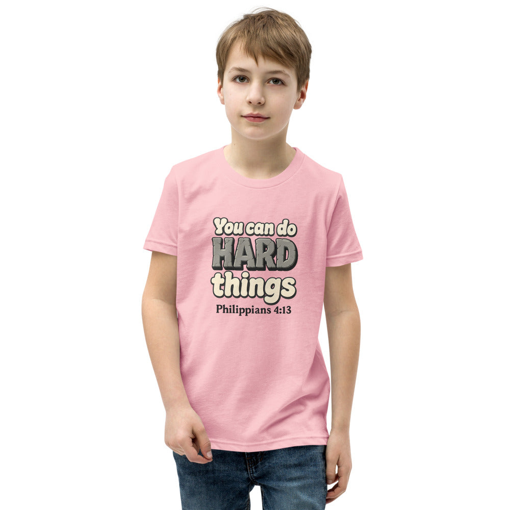 Pink youth t-shirt printed with “You can do HARD things” in cracked stone letters and Philippians 4:13