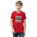 Red youth t-shirt printed with “You can do HARD things” in cracked stone letters and Philippians 4:13