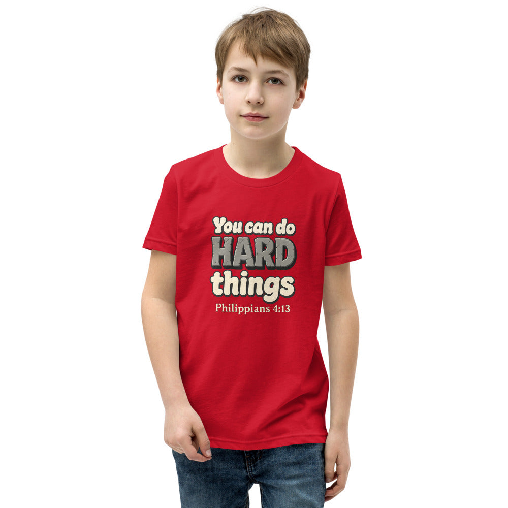 Red youth t-shirt printed with “You can do HARD things” in cracked stone letters and Philippians 4:13