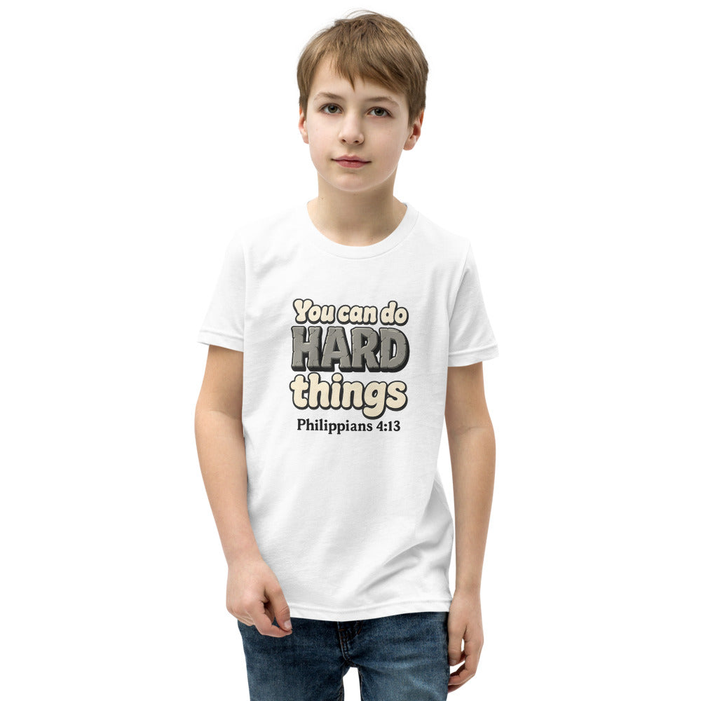 White youth t-shirt printed with “You can do HARD things” in cracked stone letters and Philippians 4:13